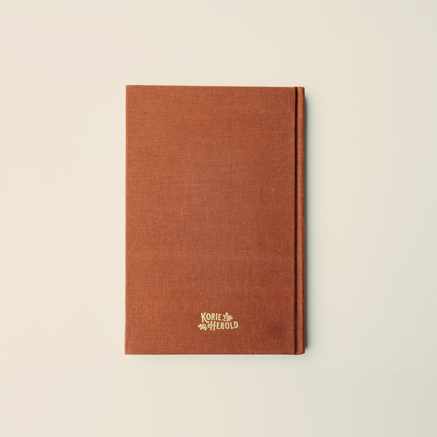 Brown notebook with a logo on a beige background