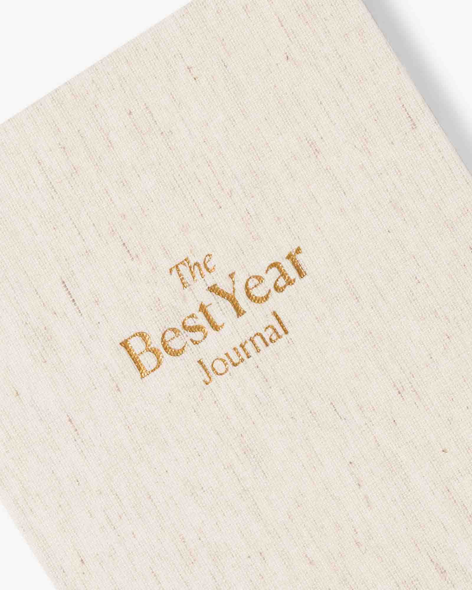 Beige journal with 'The Best Year Journal' embossed in gold on a white background