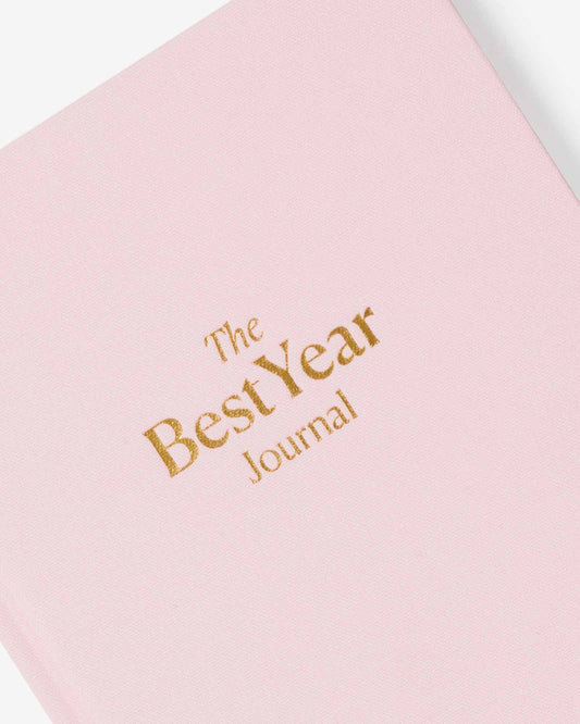 Pink journal with 'The Best Year Journal' text in gold on a white background