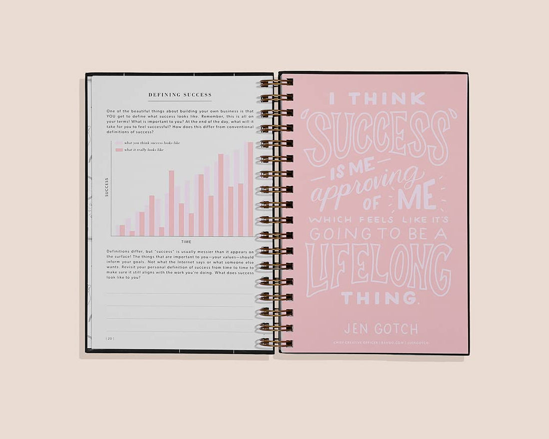 Open spiral-bound notebook with text on a light pink background