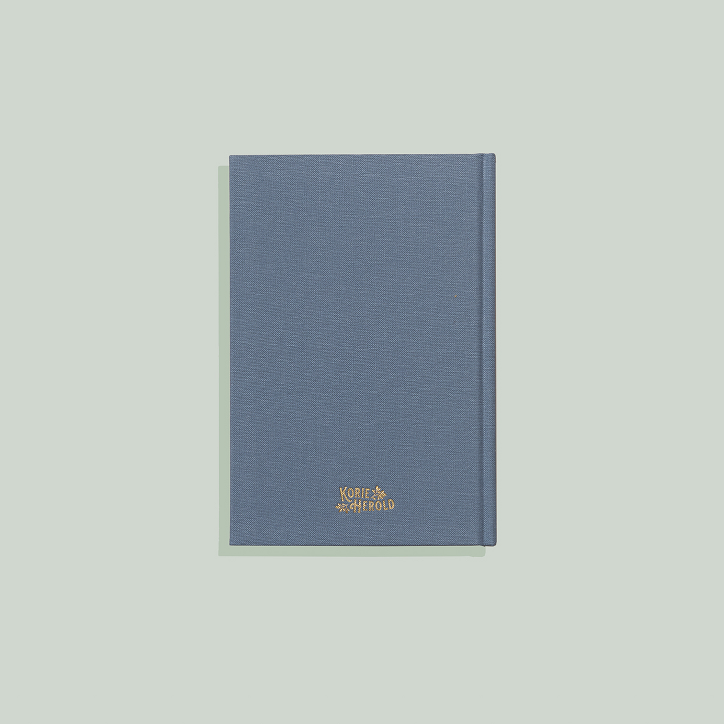 Blue notebook with a gold logo on a light gray background