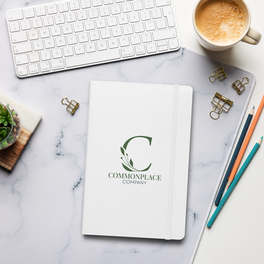 Notebook with 'Commonplace Company' logo on a marble surface with office supplies.