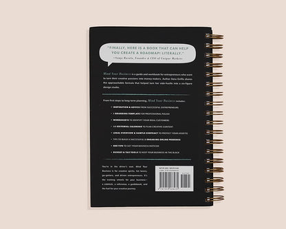 Back cover of a black notebook with text and a barcode on a beige background