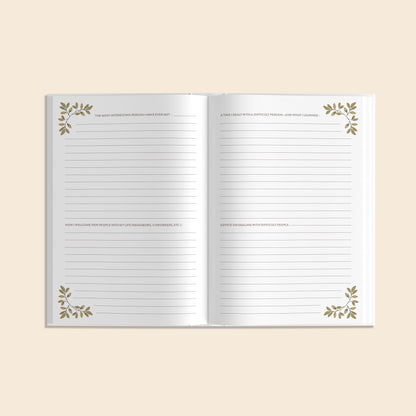 Open notebook with decorative leaves on a beige background