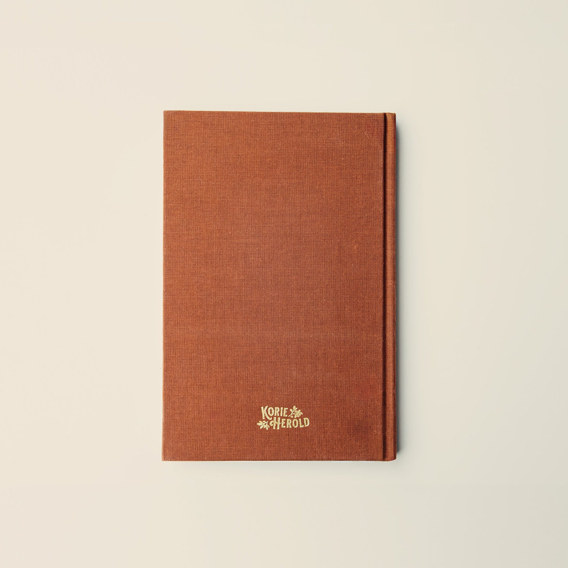 Brown notebook with a logo on a beige background
